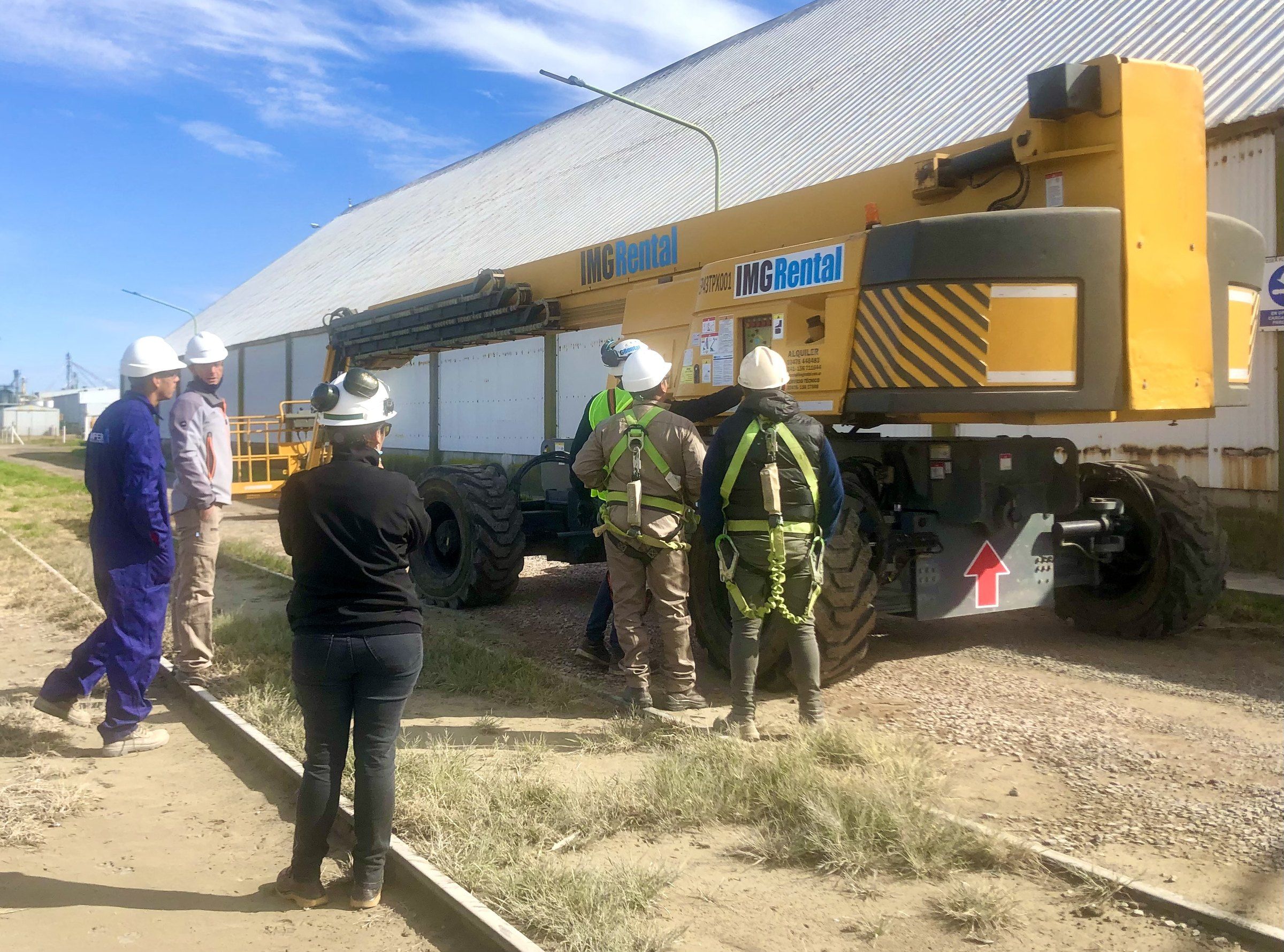 Equipo técnico con elementos de protección junto a un brazo articulado en obra